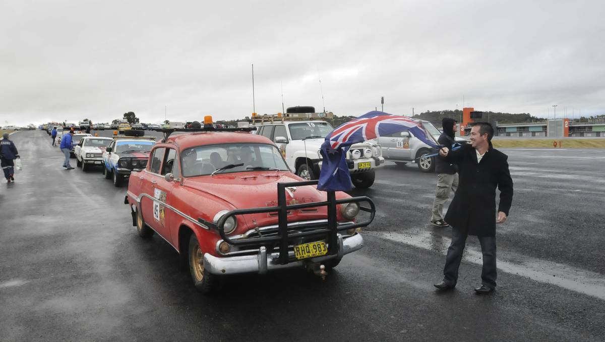 BATHURST: Bathurst MP Paul Toole waves off the first car in the annual Outback Car Trek on Sunday. The 1950s Dodge Coronet, piloted by Norman and Lorita Ridge and Bob Sinclair, has been in every trek. Photo: CHRIS SEABROOK 060213ctrek1a