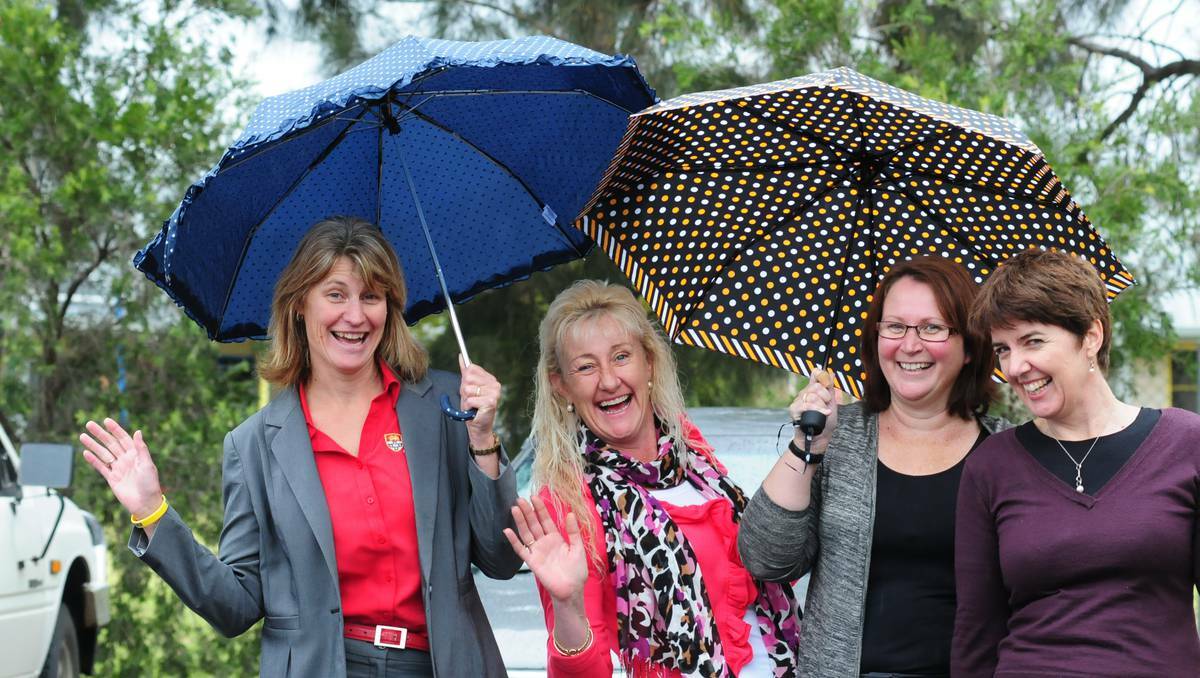 Practically singing in the rain in Dubbo on Wednesday are Karen Paxton, Jay Symons, Lisa Riley and Rebecca Ivers. Photo: LOUISE DONGES