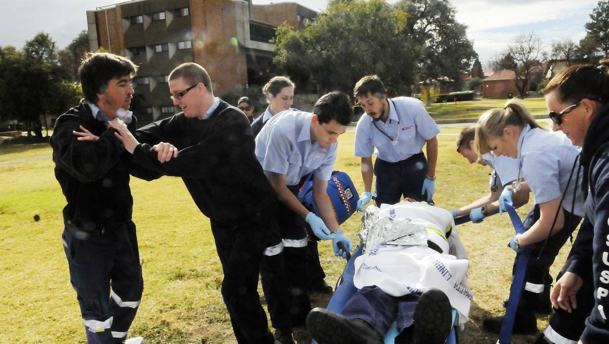 BATHURST:  In a simulation exercise, CSU paramedics student Lucy Weiner attempts to hold off Scott Parkinson, who is acting aggressively towards paramedics. Photo: PHILL MURRAY 052113ppara1