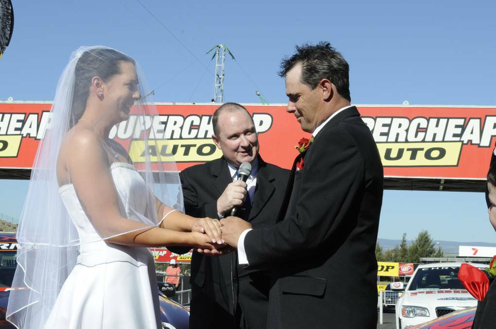 Race officials Shane and India tie the knot in Pit Lane at Mt. Panorama. Photo: CHRIS SEABROOK