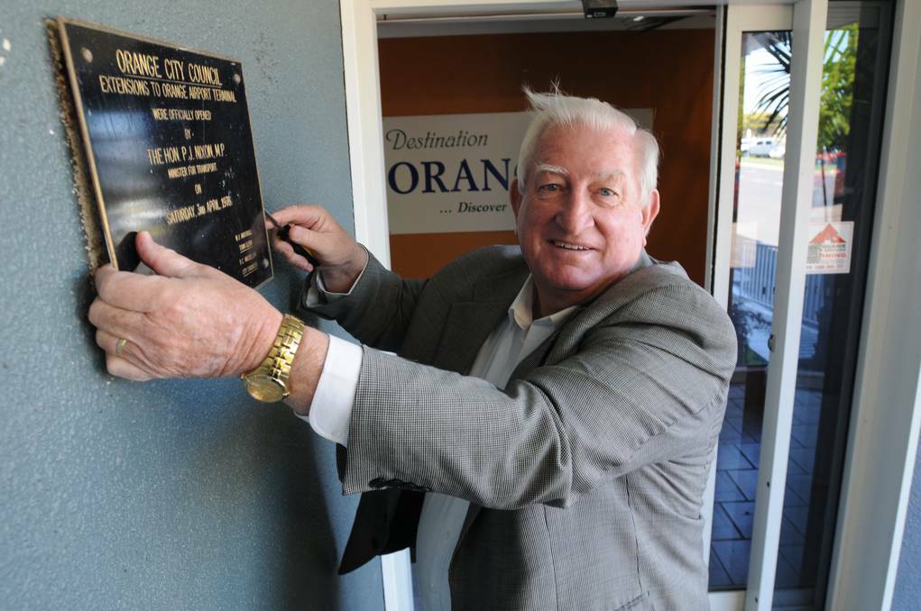  Orange mayor John Davis removes the plaque from the wall of the Orange Airport terminal ahead of its closure on Saturday.	 Photo: STEVE GOSCH 0819sgairport2