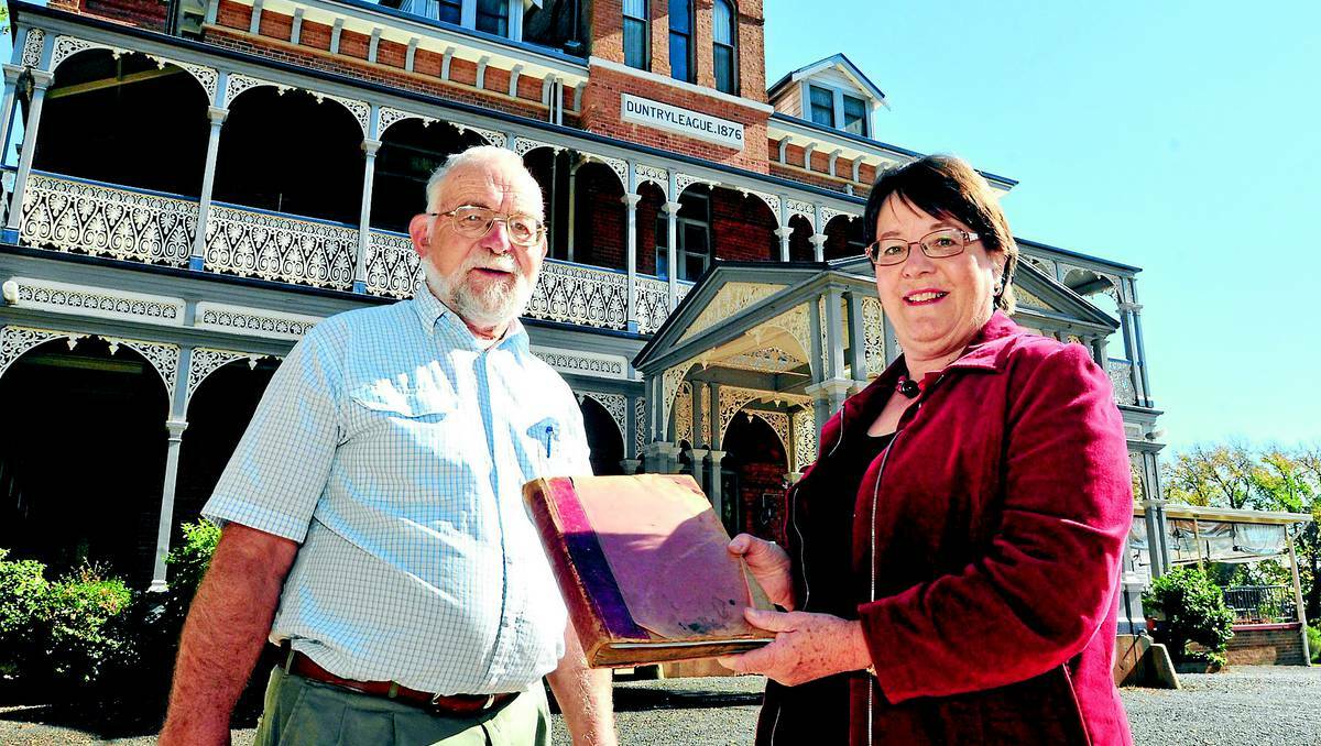 Orange and District Historical Society members Phil Stevenson and Liz Edwards hold the Summer Hill store ledger ahead of an exhibition on the Dalton family at Duntryleague in November. Photo: JUDE KEOGH 0510duntry3