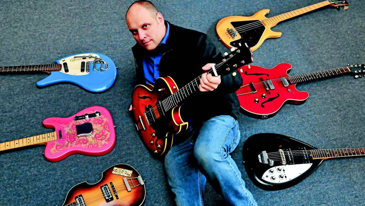 ORANGE: Lander's Music owner Ben Lander with some of the 140 guitars that will be on show at Saturday's Guitar-o-Rama. Photo: JUDE KEOGH 0614guitar1