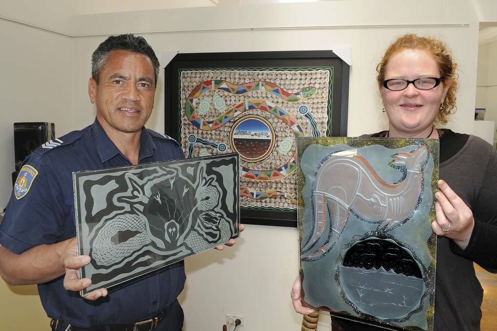 BATHURST: Girrawaa Creative Works Centre manager Bryan Reiri holds Will’s glass artwork, ‘My Dreaming’, and tutor Bridget Thomas holds Ian’s piece ‘My Totem, My Country’. Photo: CHRIS SEABROOK 092413cglass