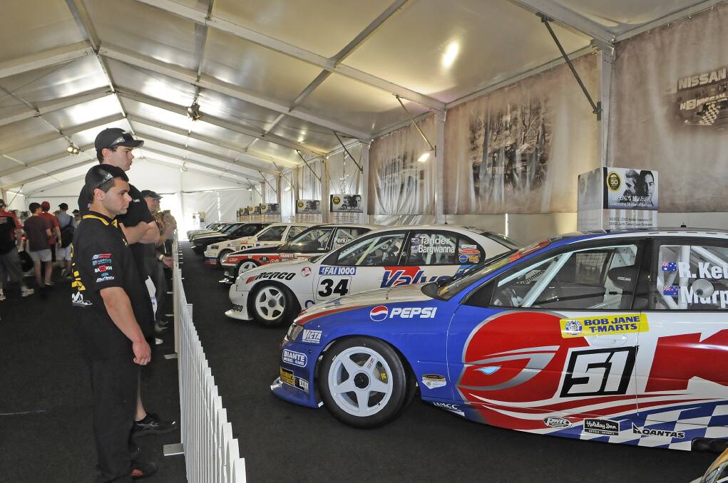 OFF TRACK: Race fans get up close and personal with the number 51 fully restored Greg Murphy Commodore which he took to a record-breaking lap to take pole for the Bathurst 1000 in 2003.	100412plegends