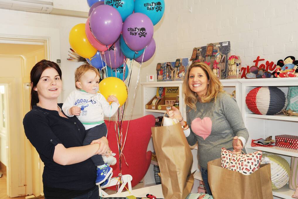 SPLURGING: Incy Interiors owner Kristy Withers (right) with another happy customer, Ainsley Roughley holding her baby Flynn Sullivan, who was grabbing a bargain or two during yesterday's Crazy Day sale. Over 90 retailers participated in the event. 090913incy