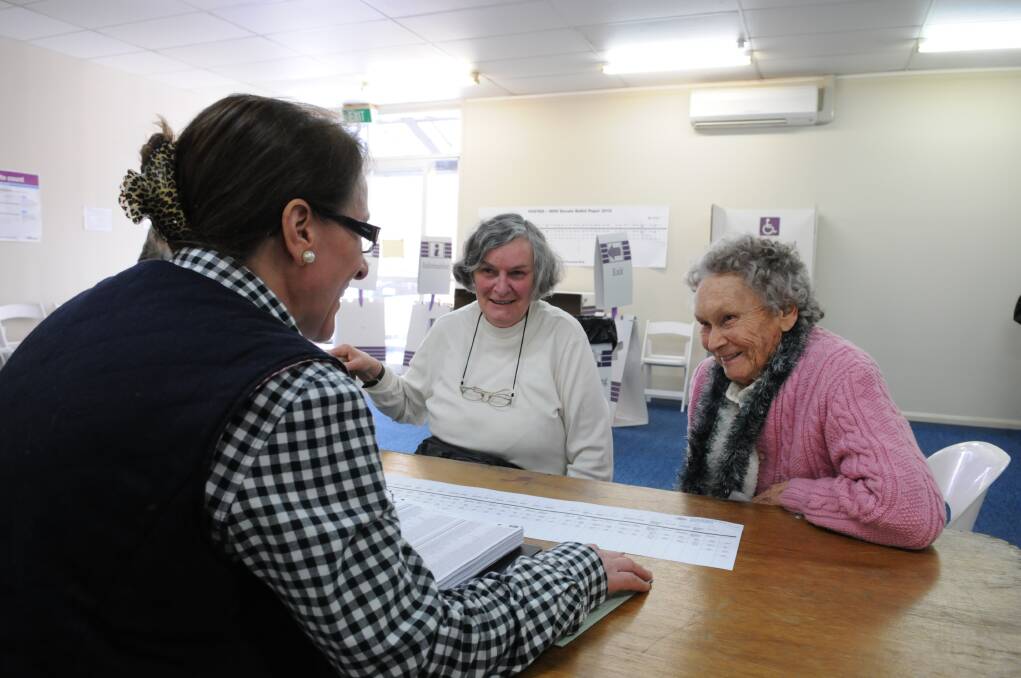 HOW TO VOTE: Officer-in-charge Mezurka Nancarrow assists local resident Betty Burns and her mother Alice Burns, from Merrygoen, with their ballot papers. Photo: ZENIO LAPKA 082613zpoll1