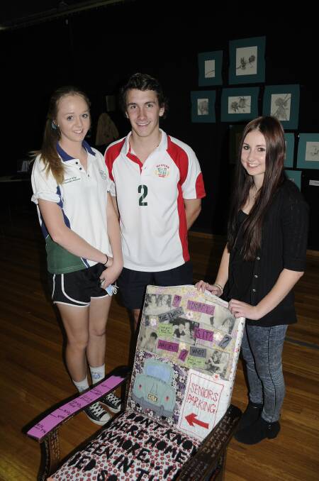 TAKE A SEAT: Amy Geyer (at right) proudly shows off her art chair to friends, Samantha Thompson and Hayden James. 