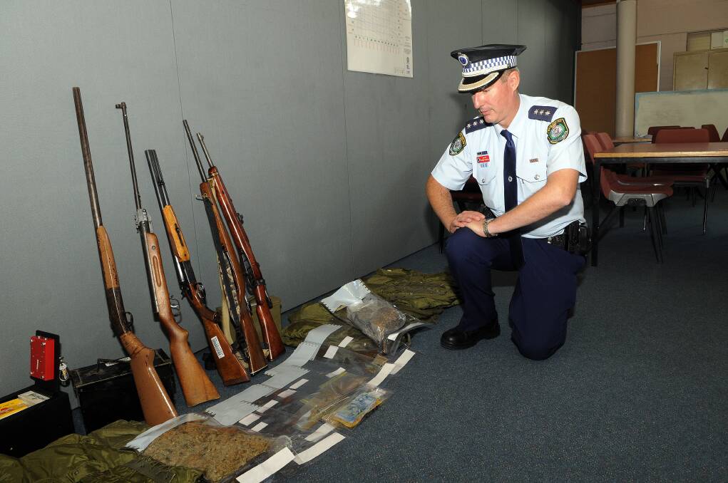 HAUL: Chifley local area command duty officer Inspector Glenn Cogdell with drugs, cash and firearms seized from an O’Connell property. Photo: PHILL MURRAY 	051713pbust