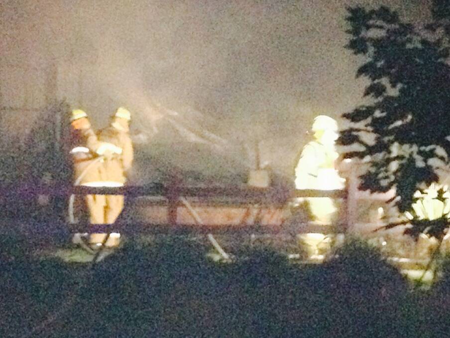 Firefighters mop up at the scene of a house fire on Havannah Street on Friday night.