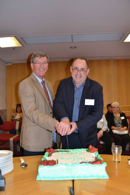 WELCOME WAGON: Mayor Gary Rush cuts the cake with new resident Steve Semmens.