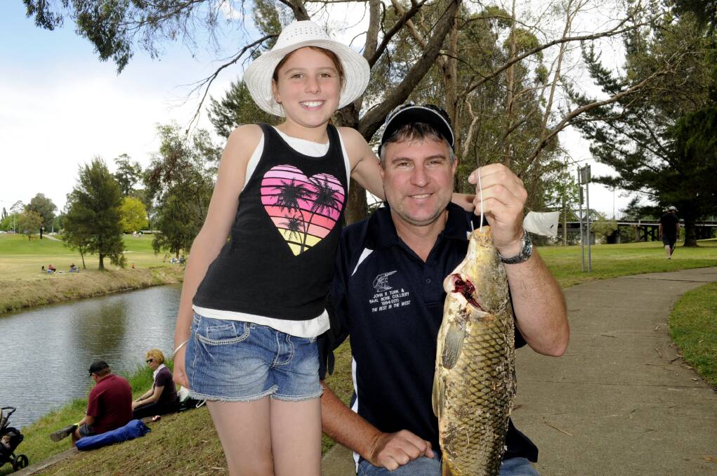 CARP BLITZ: Damien Curran with daughter, Emilee and the 1.88kg carp they caught near Eglinton.
