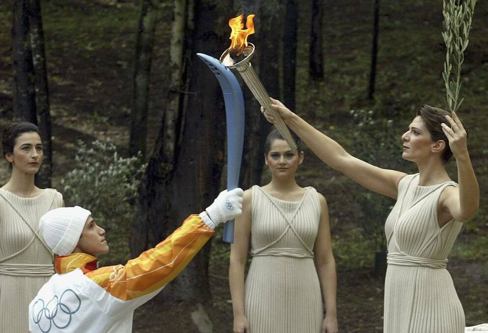 Greek athlete Costas Fillipidis, the first torchbearer, recives the flame from actress Theodora Siarkou who plays the role of high priestess during the Ceremony of the Lighting of the Olympic Flame for the Torino 2006 Winter Olympic Games. Photo: Getty Images