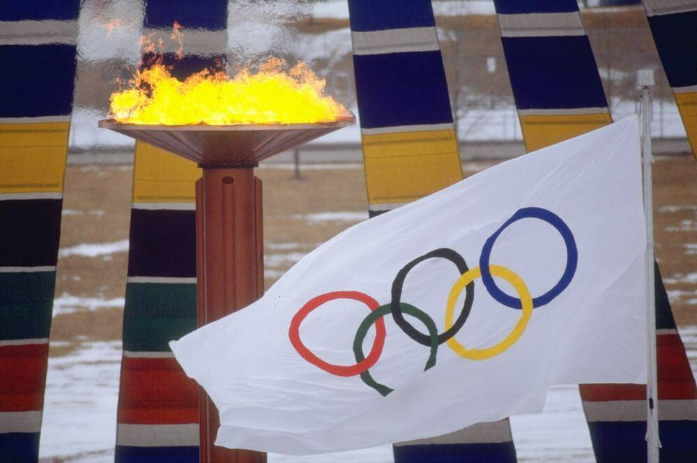 The Olympic flag and flame at the 1988 Winter Olympic Games in Calgary, Alberta, Canada. Photo: Getty Images
