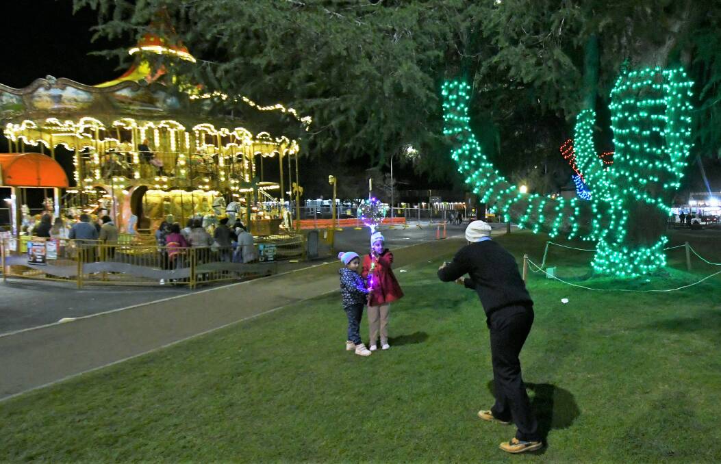 FINAL NIGHT: A parent recording a Bathurst Winter Festival moment with his kids on Saturday night. Photo: CHRIS SEABROOK