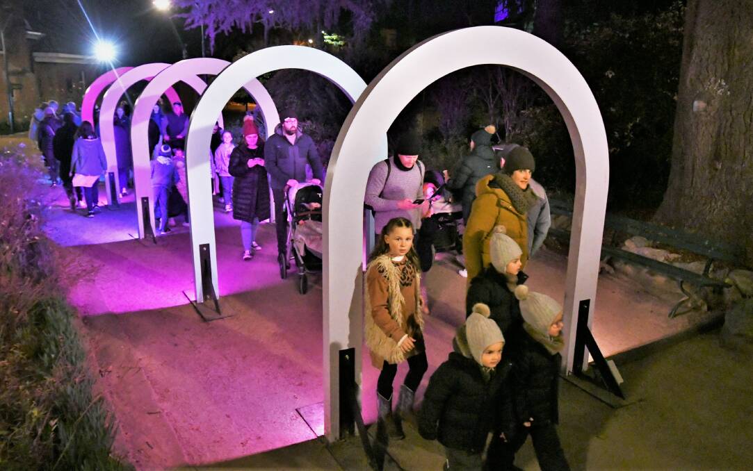 Families going through the arches in Machattie Park Saturday evening at the Winter Festival. Picture: Chris Seabrook 070922cwintrfst5