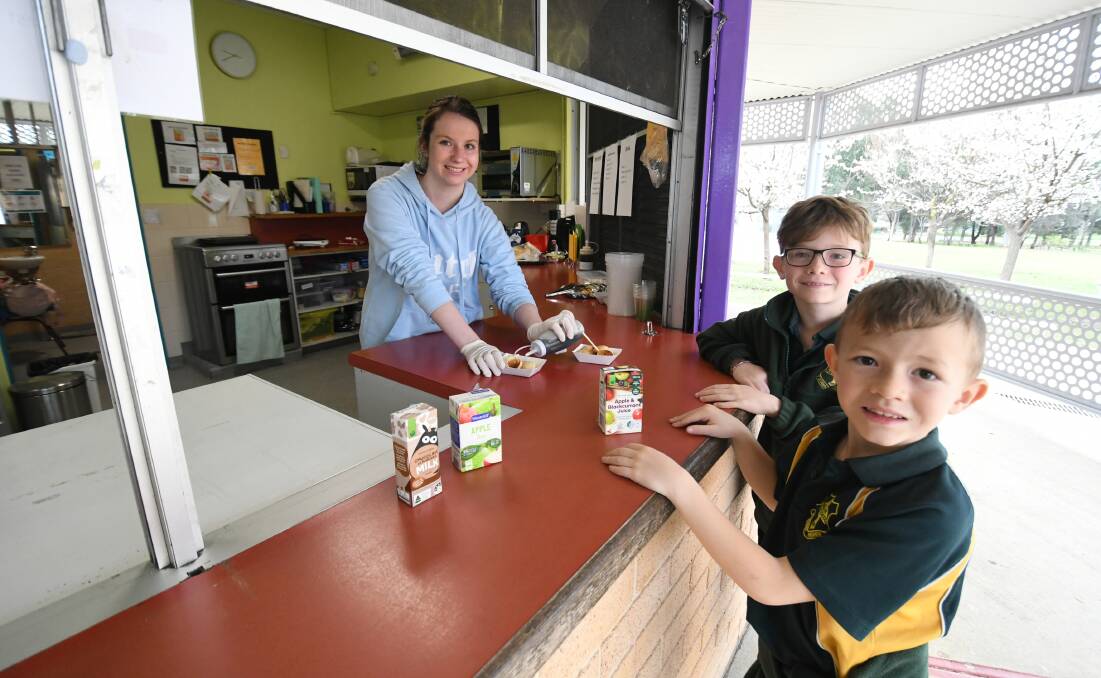 Volunteer Lara Matheson serves up mini pancakes to brothers Emmett and Carter Russell at the Raglan Public School Canteen. Picture by Chris Seabrook 