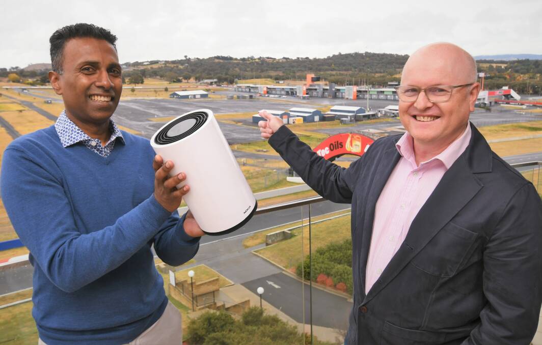 5G ROLLOUT : Managing director of Networks Optus Lambo Kanagaratnam holding a home internet device with vice president of regulatory and public affairs Andrew Sheridan pointing to one of the 5G towers. Photo: CHRIS SEABROOK 