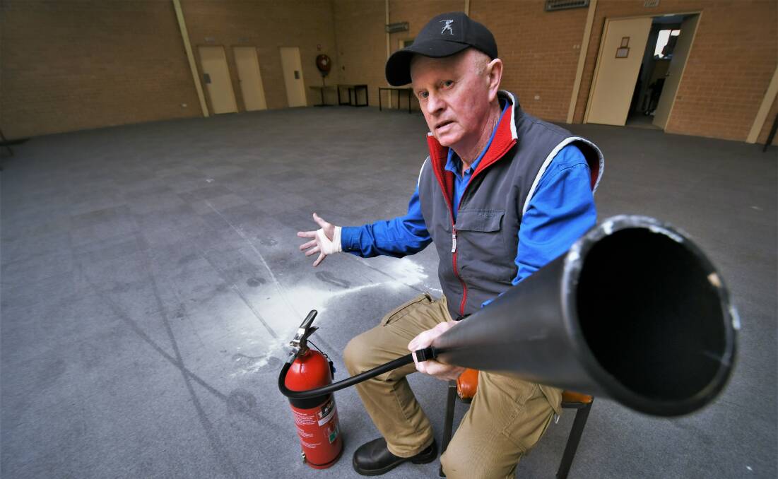 VANDALISM: Graeme Stapleton with the emptied fire extinguisher used to damage the Raglan Community Hall. Photo: CHRIS SEABROOK.