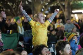 Matildas fan Addison Irvine, 7, cheers on the green and golds at the Canberra live site in Garema Place. Picture by Keegan Carroll