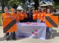 Housing Plus staff were dressed in their orange attire for the 'Going Nuts in the Bush' event, with senior constable Robert Punnett.