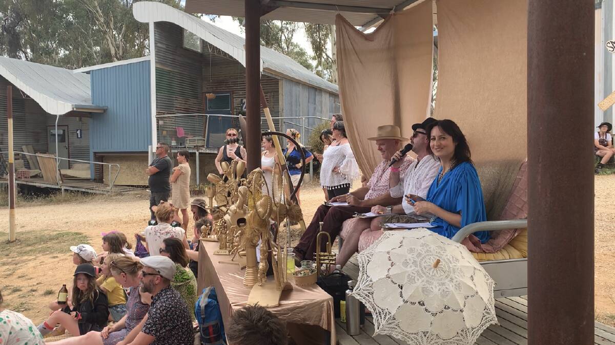 Judges at this year's Castlemaine Idyll surrounded by the quirky gold statues made by artist Mark Anstey and given as trophies. Picture by Anna Houlahan