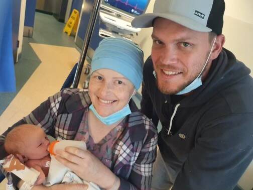 DIGGING DEEP: Amy Gullifer (centre), pictured with her son Wesley (left) and partner Adam Powell (right), has raised over $80k for cancer treatment. Photo: CONTRIBUTED