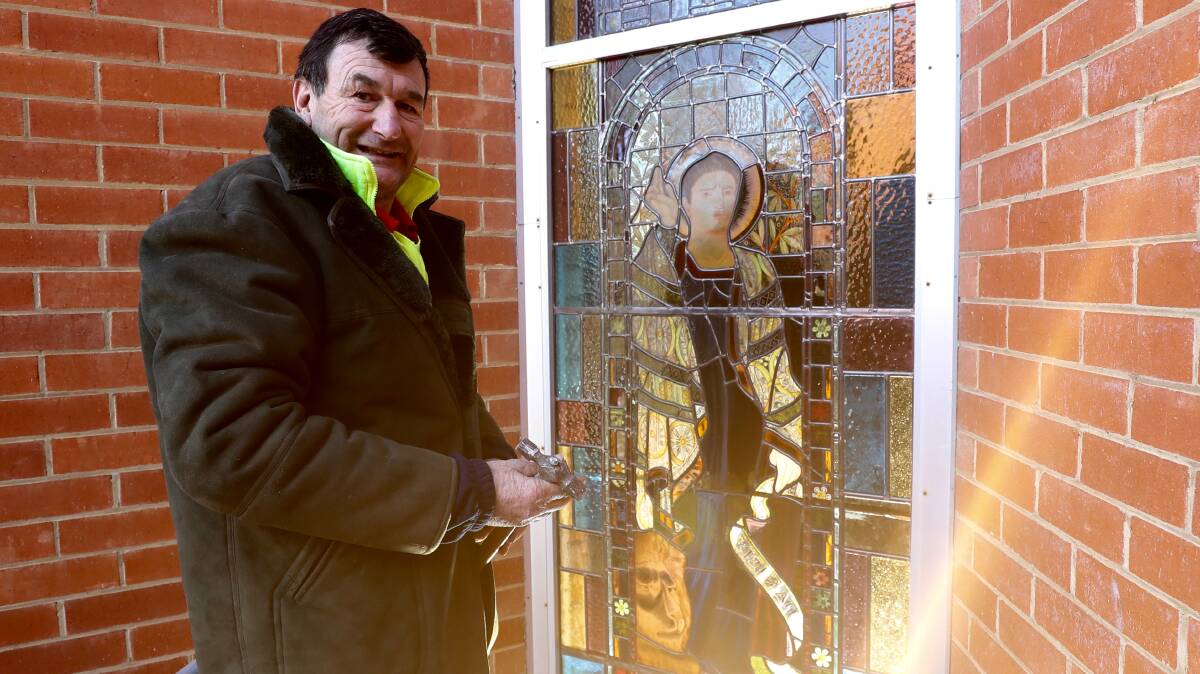 REFURBISHMENT: Michael Robinson with the repaired stained glass window at the All Saints Anglican Cathedral. Photo: PHIL BLATCH