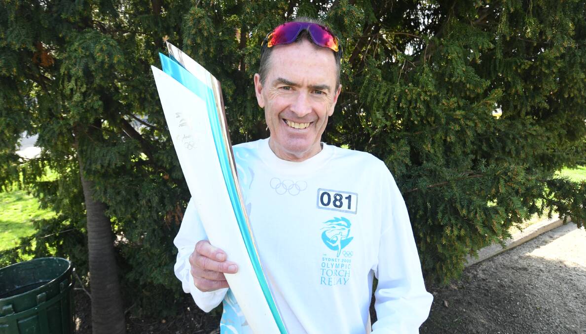 HONOUR: Bathurst cyclist Mark Windsor with his replica torch and jersey from when he carried the Olympic torch through Bathurst back in 2000. Photo: CHRIS SEABROOK
