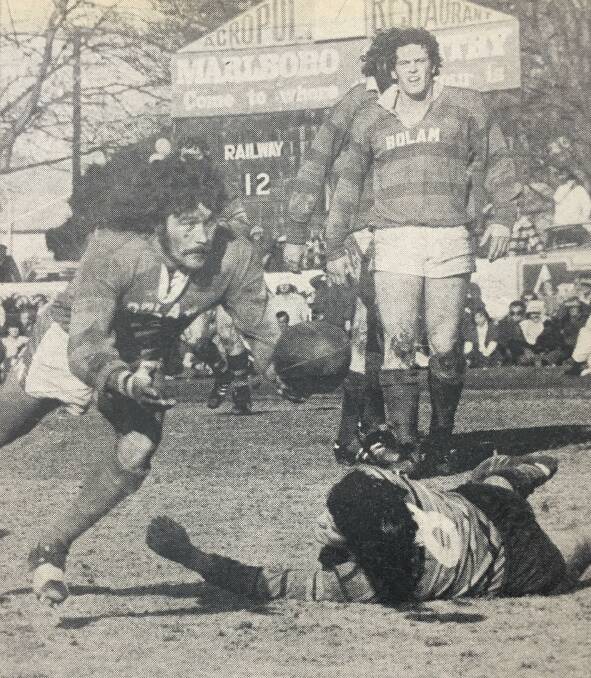 WINNER: Bathurst Railway's Geoff Lousick evades the tackle of Lithgow's player Mark Warren in 1976 grand final. Nev Cousins is pictured in the background. 