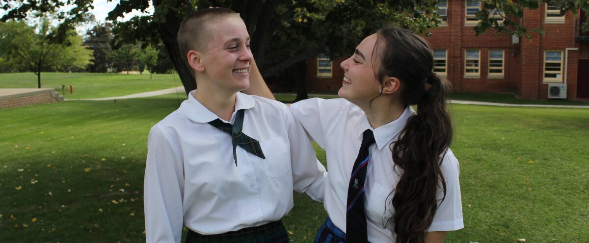 FUNDRAISING: Scots All Saints student Stella Gavey (left) got her hair cut off by classmate Grace Milton (right). Photo: BRADLEY JURD
