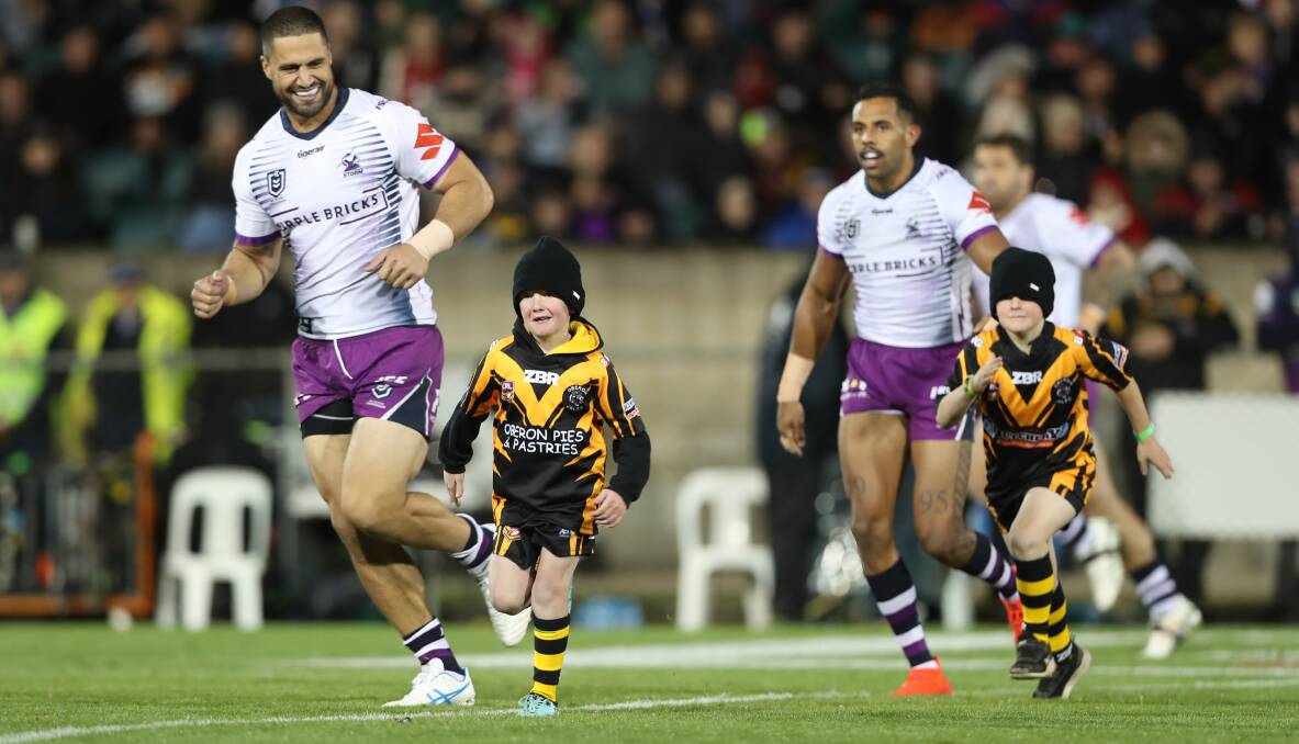 NRL IN BATHURST: Melbourne Storm players Jesse Bromwich and Josh Addo-Carr lead two Oberon Tigers juniors onto the field back in 2019. Photo: PHIL BLATCH