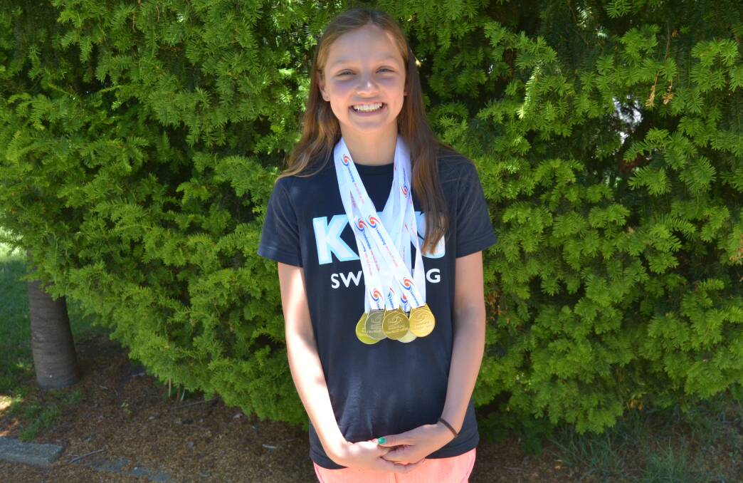 GOLD WINNER: Collette Lyons with her impressive haul of medals from the state age championships. Photo: BRADLEY JURD 121916bjswimming