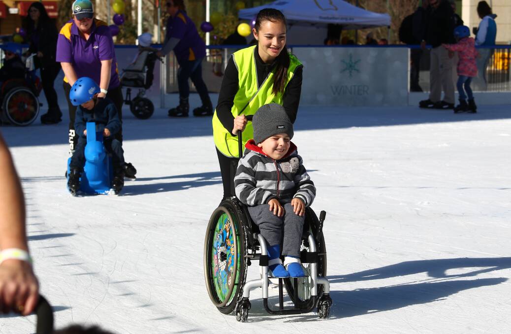 HAVING A GO: Siobhan Wilde pushes DJ Owen at LiveBetter's Accessibility Day at the McDonald's Bathurst Ice Rink on Wednesday. Photos: PHIL BLATCH 070517pbskate3