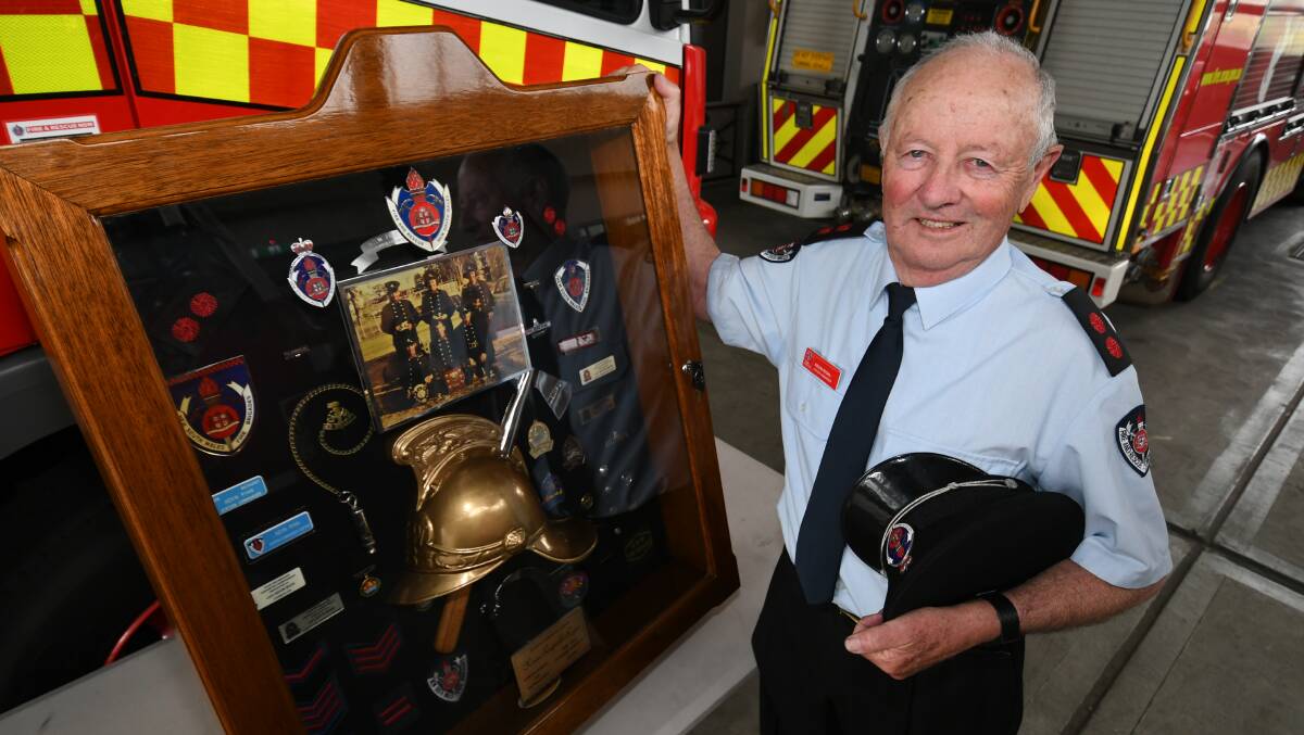 LONG GIG: Bathurst Fire Station commander captain Kevin Ryan with a display cabinet presented to him after 50 years of service. Photo: CHRIS SEABROOK