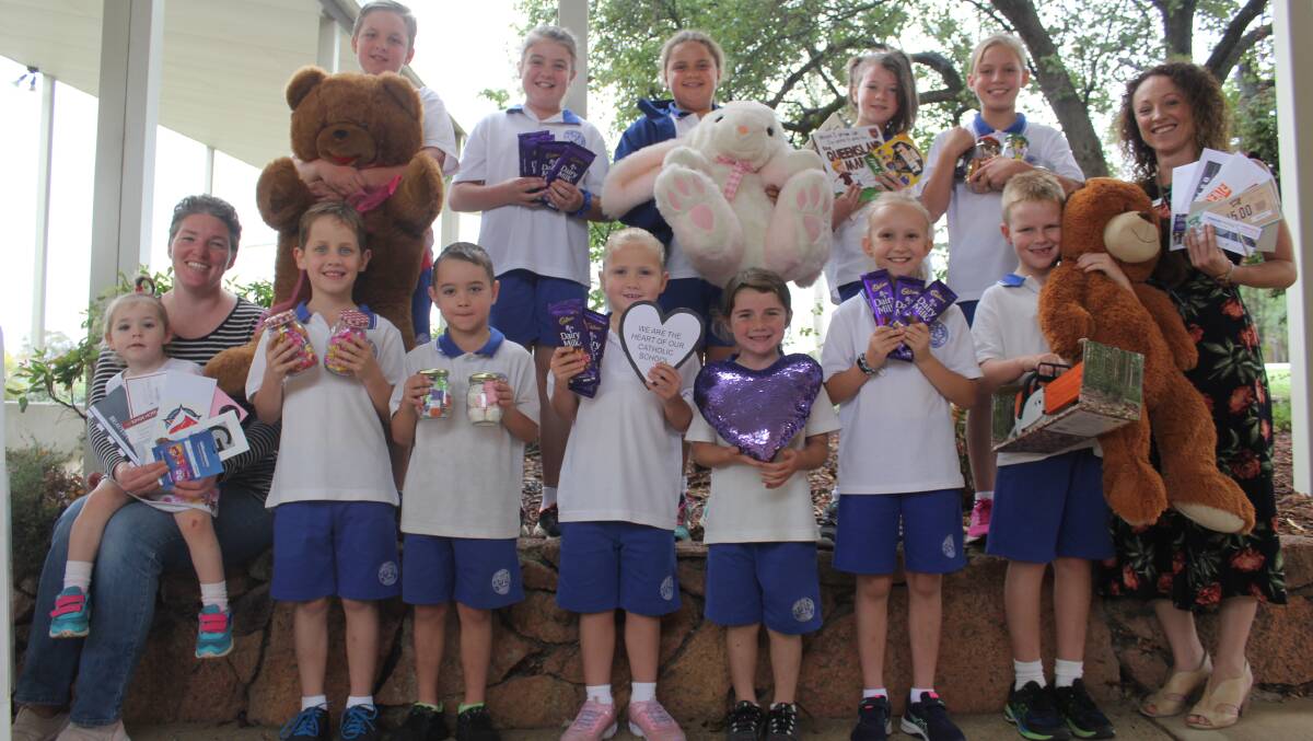 FETE: Students from St Philomena's Primary School, with some of the goods that will be up for grabs at the school fete on Friday. Photo: BRADLEY
