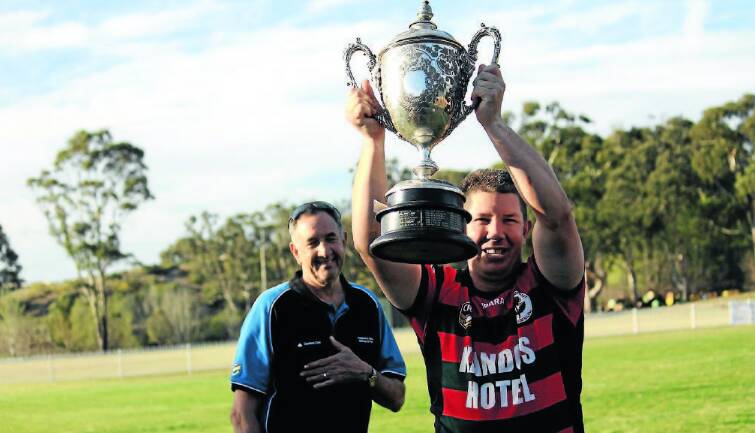 CHAMPIONS: Mid West Cups Neil Larcombe watches as Kandos Waratahs captain Glenn Osgood holds the Blayney Citizens' Cup in 2013. 