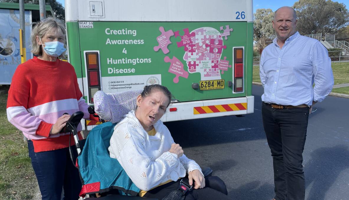 AWARENESS: Carer Sharon Perkins with Kim Draper and Vivability CEO Nick Packham, if front of one of the Bathurst buses with the Huntington's disease awareness ad. Photo: BRADLEY JURD