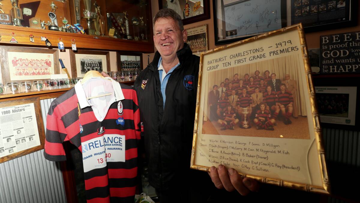 SUCCESS: Charlestons' 1979 grand final-winning player Royce George, with an old jersey and a photo of the team with the premiership trophy. Photo: PHIL BLATCH