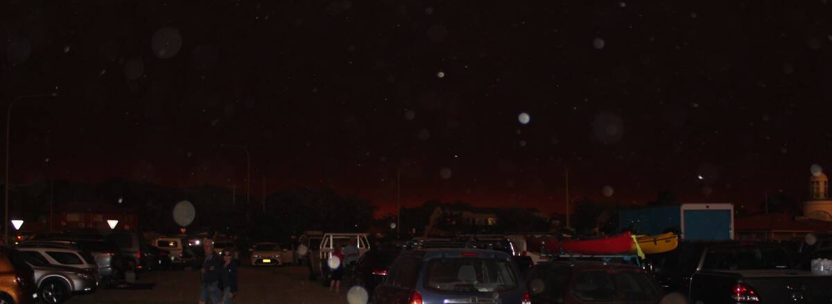 Narooma on the evening of December 31. The flash of the camera has bounced off the many pieces of ash in the air. Photo: SUPPLIED
