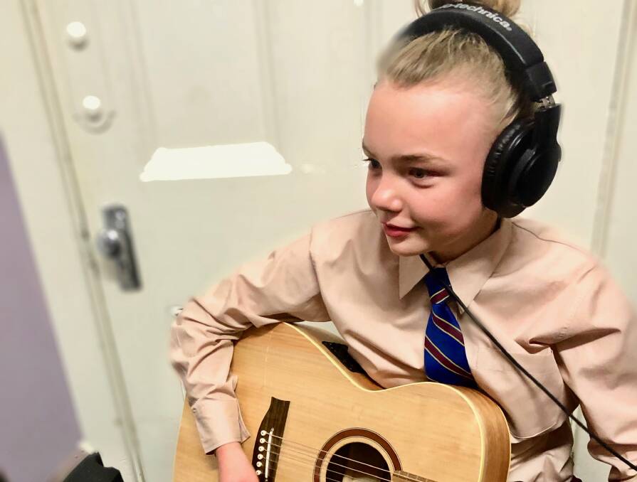 FOR THE MOTHERS: Cathedral Catholic Primary School year 6 student Audrey Peters plays guitar while her piece is recorded. Photo: SUPPLIED