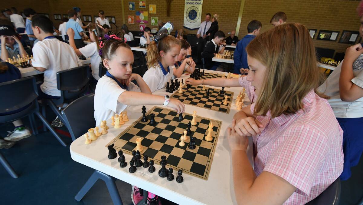CHECKMATE: St Philomena's year 3 student Charlotte Murphy makes her move against The Assumption School year 6 student Charlee Small. Photo: CHRIS SEABROOK 102418chess1a