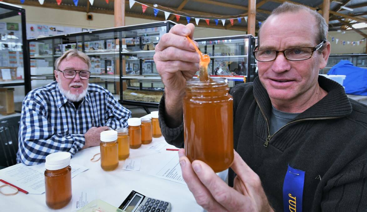 A GOLDEN MOMENT : Nick Annand (right) judging jars of Amber Honey. Looking on is Chief Steward Wayne Hammond. Photo: CHRIS SEABROOK