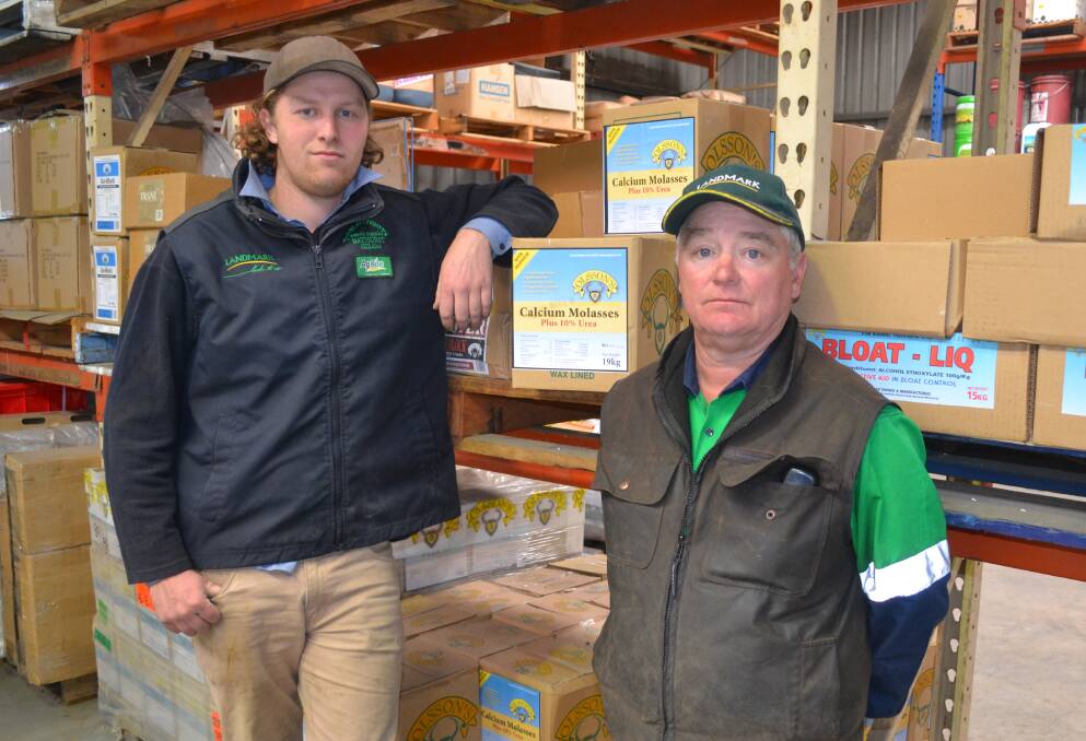 DRY SPELL: Town and Country Rural Supplies’ Corey Tubnor and Chris Arrow, with calcium molasses which provides the appropriate nutrients that cows lack when there is a lack of grass. Photo: BRADLEY JURD 081717bjdry