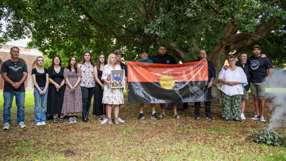 Family and friends stand united at Dubbo Court House, holding a banner saying 'stop Aboriginal deaths in custody'. Picture by Belinda Soole 