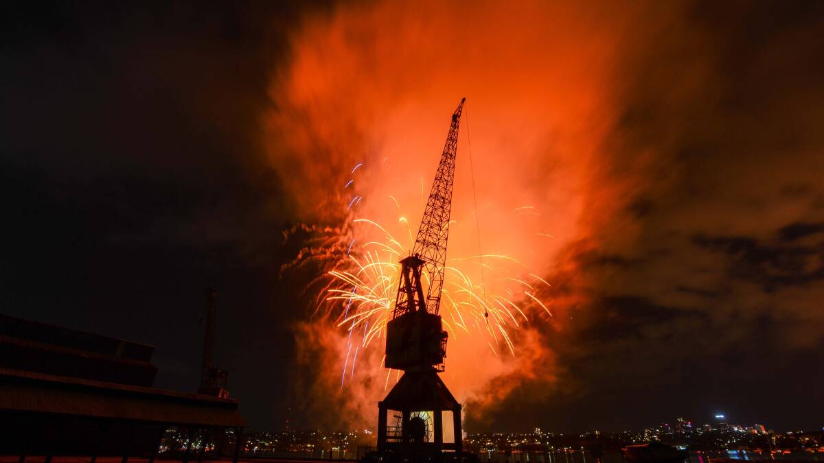 An intriguing juxtaposition … Cockatoo Island’s historic Bolt Wharf crane silhouetted by New Year’s Eve fireworks. Image: Ian Evans.