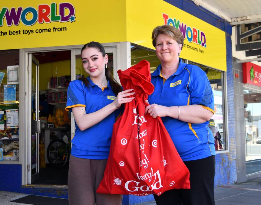 Katie Brennan and Tara Laranch of Toyworld Bathurst out the front of the Bathurst store with a bag of donations for Central West kids. Picture by Jay-Anna Mobbs