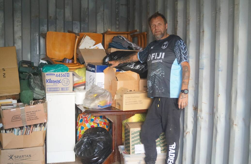 LIFE-CHANGING: Sean Griffiths in a shipping container in Bathurst filled with supplies waiting to be sent to Fiji.