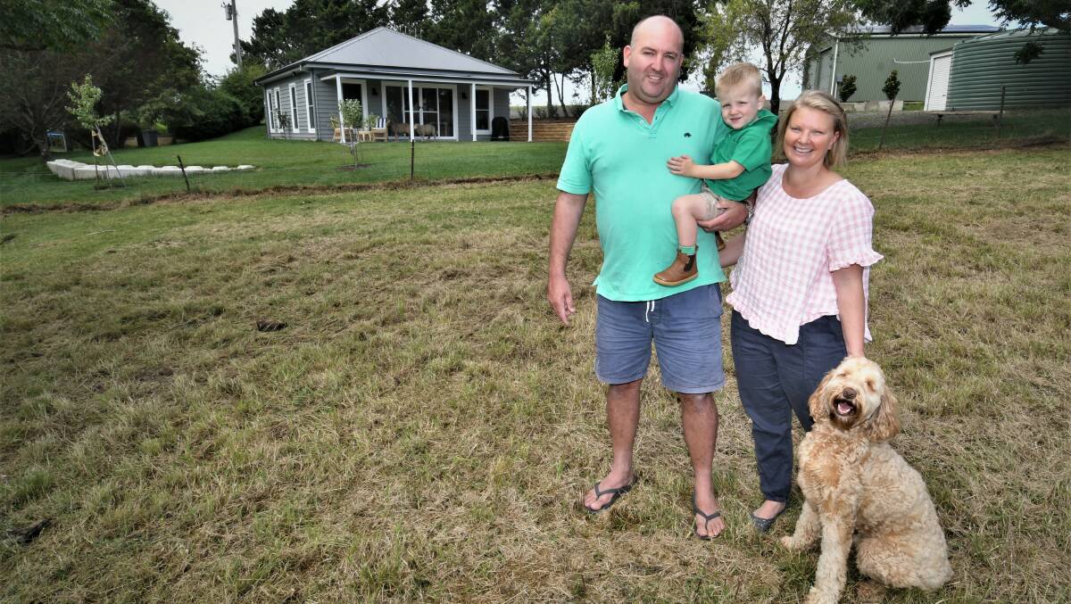 RURAL RETREAT: Daniel and Annika Collins, their son Angus, 2, dog Bella and the cottage on their property. Photo: CHRIS SEABROOK 033022cbnb1