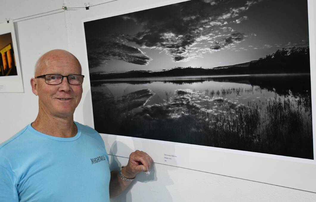 DAM FINE: Photographer Warren Lloyd with his favourite black and white photo of Chifley Dam, taken early in the morning. Photo: CHRIS SEABROOK 112320cwlloyd